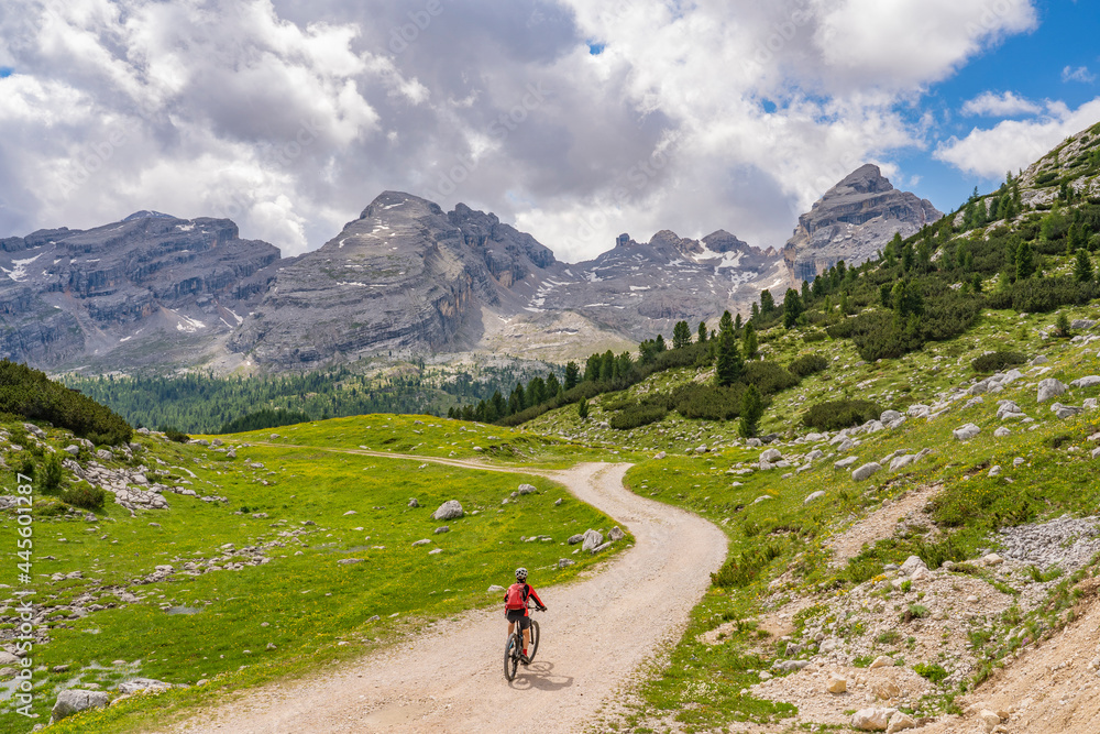 pretty active senior woman riding her electric mountain bike in the Fanes high Valley, part of Fanes-Sennes-Braies nature park in the Alta Badia Dolomites,  South Tirol and Trentino, Italy
