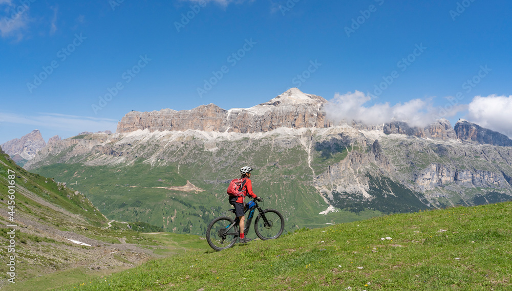 pretty active senior woman riding the famous Sella Ronda mountain bike Trail in Sella mountain group, Dolomites of Selva Wolkenstein, Val Gardena, South Tirol and Trentino, Italy pretty active senior woman riding the famous Sella Ronda mountain bike Trail in Sella mountain group, Dolomites of Selva Wolkenstein, Val Gardena, South Tirol and Trentino, Italy