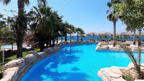 Wallpaper Mural Beautiful view of a tropical paradise without people. Swimming pool, palm trees, straw umbrellas. Sunny Day. Elite Holidays Resort.HD video Torontodigital.ca