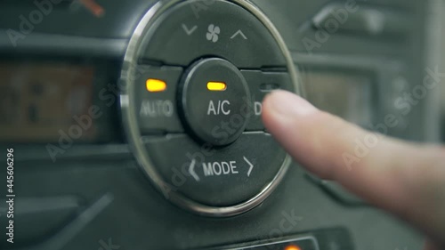 Turning on AC (air conditioning) on car front panel.  photo
