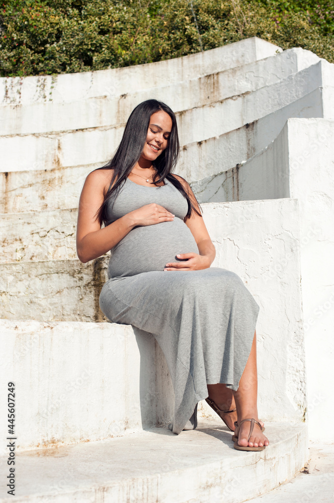 Young pregnant Brazilian woman touching her belly Young pregnant Brazilian woman touching her belly