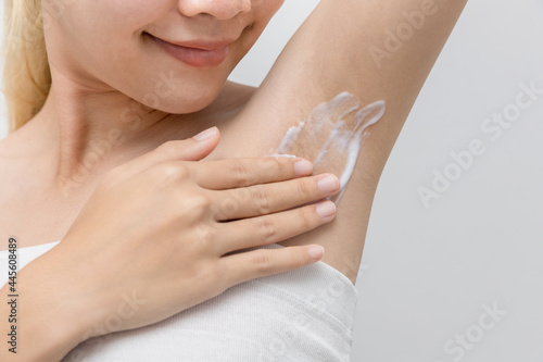 Skin care. Hair removal concept. A woman after a shower moisturizes her skin. Apply shaving cream on your armpits to get rid of hair in the bathroom at home.