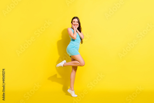 Full size profile photo of fancy brunette hairdo young lady wear teal dress isolated on vivid yellow color background