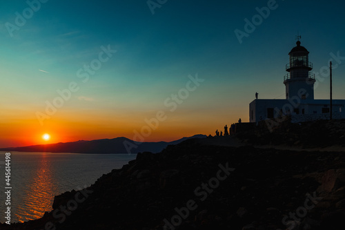 Silhouette of a lighthouse during orange sunset in Mykonos, Greece