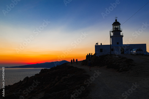 Silhouette of a lighthouse during orange sunset in Mykonos, Greece