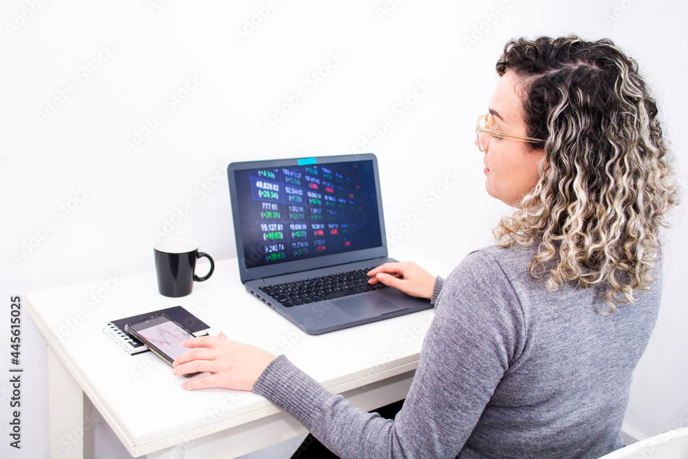 young woman analyzes financial charts in home office young woman analyzes financial charts in home office
