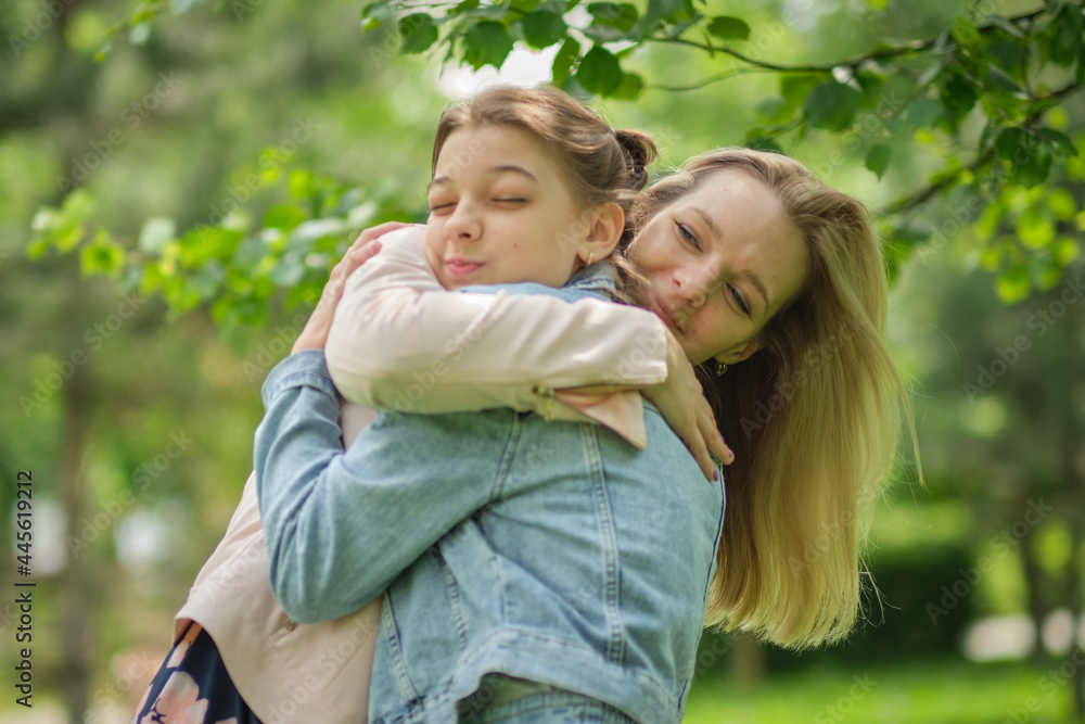 happy mother with her daughter hugging a teenager in the summer. Caring happy mother enjoy day with teenage girl child, laugh have fun. Mother giving her daughter advice. happy mother with her daughter hugging a teenager in the summer. Caring happy mother enjoy day with teenage girl child, laugh have fun. Mother giving her daughter advice.