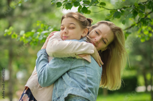 happy mother with her daughter hugging a teenager in the summer. Caring happy mother enjoy day with teenage girl child  laugh have fun. Mother giving her daughter advice.