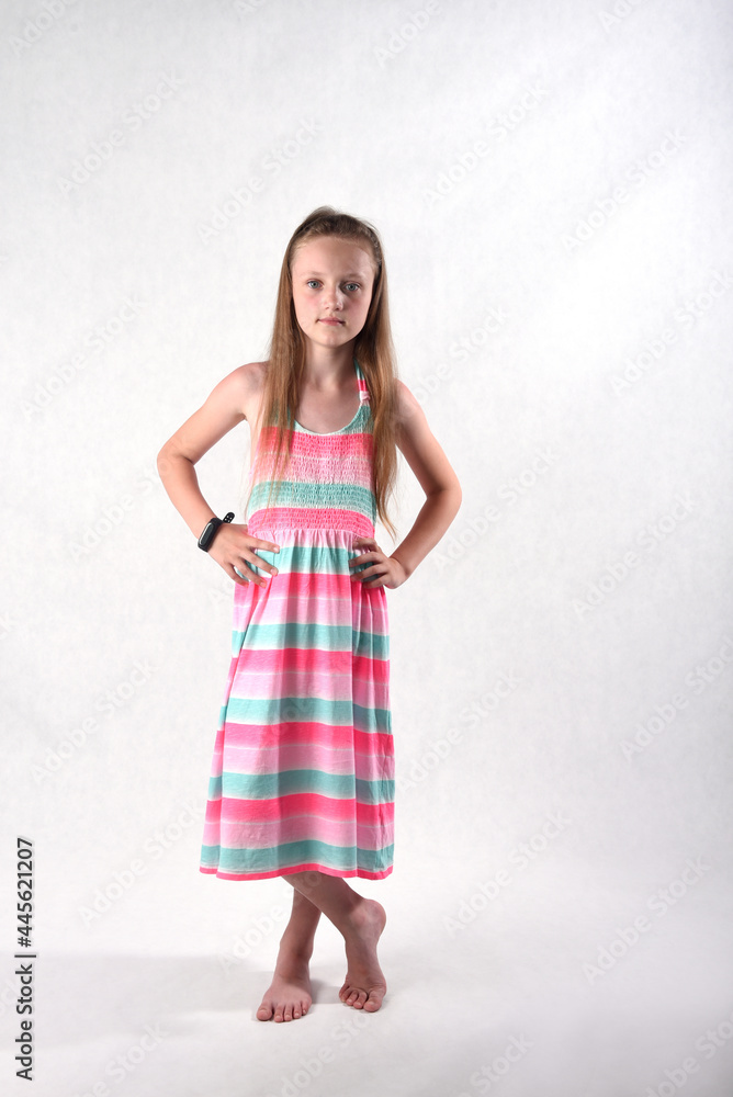 A beautiful school-age girl in the studio on a white background in a beautiful full-length dress A beautiful school-age girl in the studio on a white background in a beautiful full-length dress
