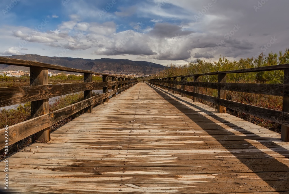 Obraz premium Wooden path bridge at Mediterranean sea overview, sunset summer evening