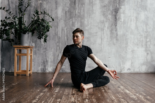 A young man performing yoga asanas and sports exercises to improve the strength and flexibility of the body