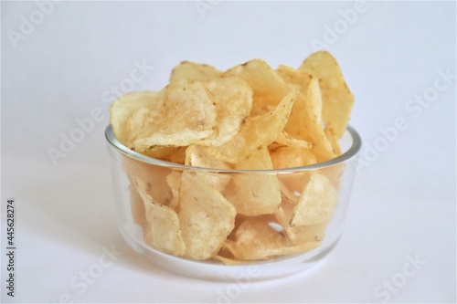 Aliments et chips. Patates et chips dans un bol transparent. Plaisir et dégustation. Collation et fringale. Casse-croûte et chips. Croustilles et patates.