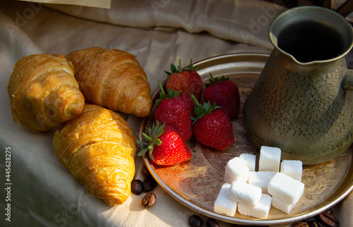 Breakfast with strawberries, croissant   and coffee on wooden table