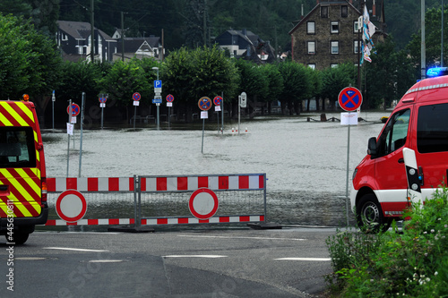 Absperrung und Verkehrsschild Verbot der Durchfahrt und Fahrzeuge der Feuerwehr vor überflutetem Parkplatz bei Hochwasser am Rhein in Vallendar bei Koblenz - Stockfoto