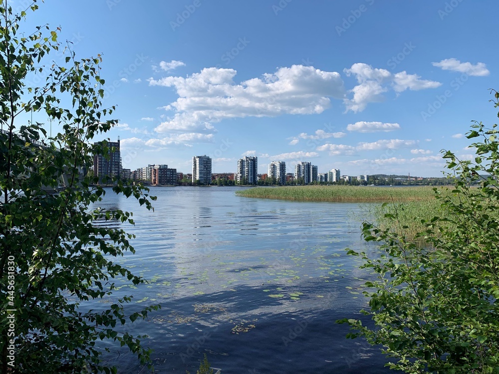 View over the lake to an urban town district. Living in a modern apartment close to the nature, services and city center. The photo is taken in Jyväskylä, Finland.