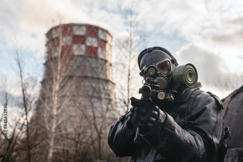 Post apocalypse soldier with a rifle and in the gas mask on the factory chimney background. Post apocalypse soldier with a rifle and in the gas mask on the factory chimney background.
