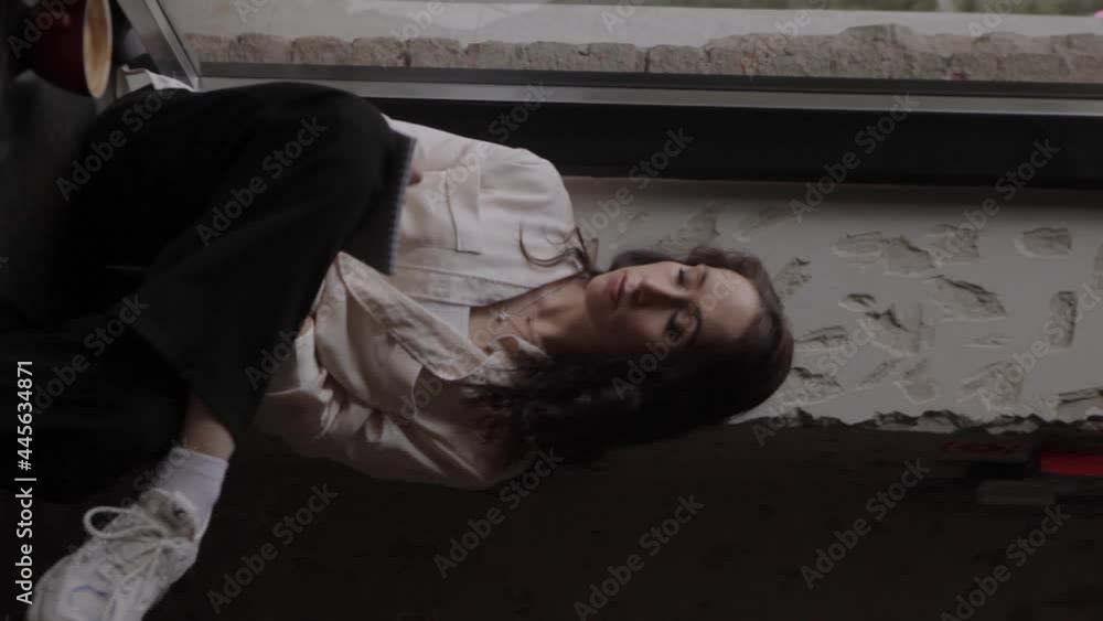 A woman writes notes in a notebook. The girl sits at the window and thinks. A moment of reflection and calm