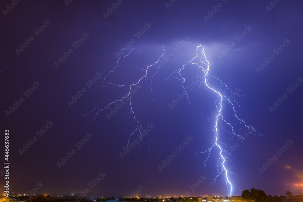 Fototapeta premium Cloud to ground bright lightning strike over Johannesburg at nighttime