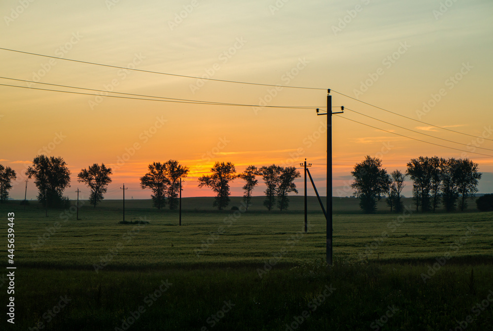 Morning sunrise over a landscape with a green field
