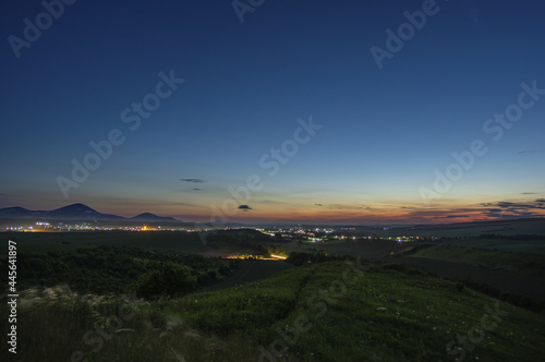 Beautiful evening landscape, mountains at sunset and city lights in Ukraine