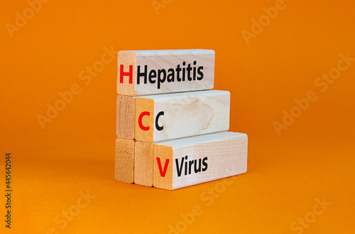 HCV, hepatitis C virus symbol. Wooden blocks with words HCV, hepatitis C virus on beautiful orange background. Medical, HCV, hepatitis C virus concept. photo