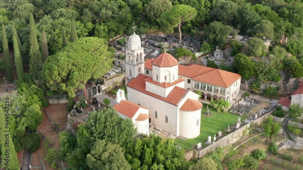 Old Christian monastery surrounded by green park and garden. Secluded orthodox religious chapel on the hillside with lush vegetation. Aerial drone view of Savina abbey in Montenegro, Europe. Old Christian monastery surrounded by green park and garden. Secluded orthodox religious chapel on the hillside with lush vegetation. Aerial drone view of Savina abbey in Montenegro, Europe.