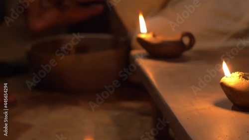 The Lord Jesus washes the feet of His disciple under the light of an ancient retro oil lamp, movie scene shot