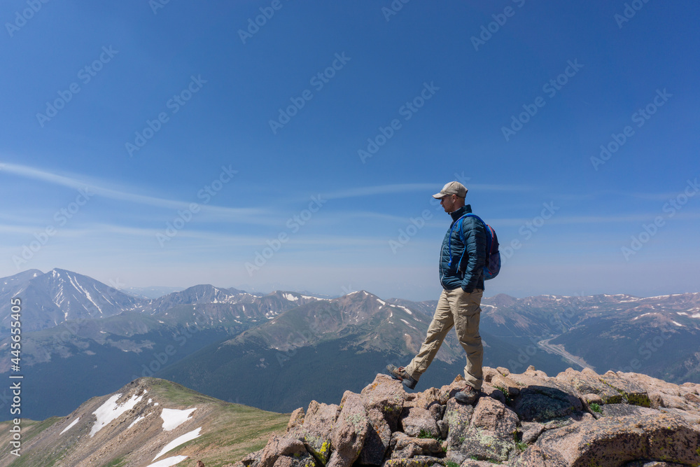 Hiker on top of Mount Parnassus in Colorado looking off into the distance