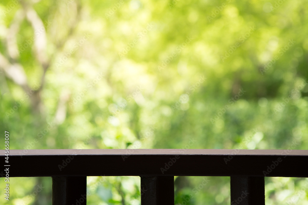 Selective focus of Wooden slatted balcony on natural blurred background with sunlight Selective focus of Wooden slatted balcony on natural blurred background with sunlight