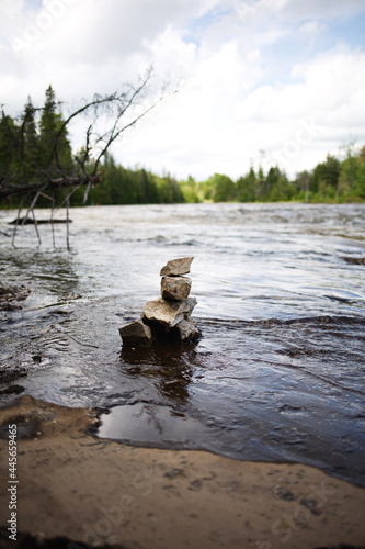 A small inukshuk along the side of a river in rural Ontario, Canada. A traditional symbol of the Indigenous people who used to live here.
