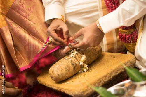 Traditional ritual of putting a ring on the bride's toe during a Hindu wedding ceremony photo