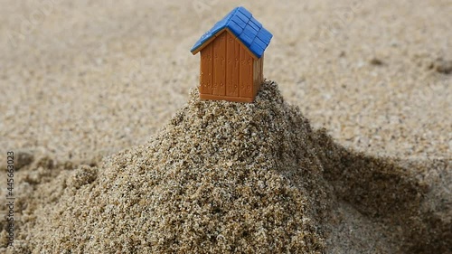 崩れ落ちる砂の上から転げ落ちる家のミニチュアのスローモーション動画
 photo