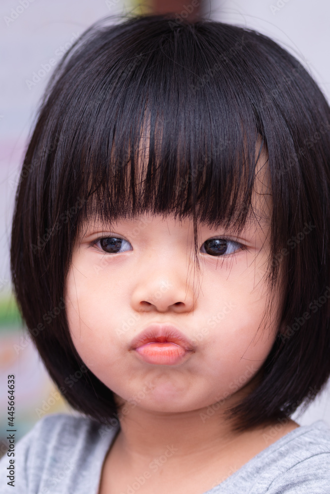 Portrait of Asian adorable girl. Kid make wrapping her mouth. Head shot of cute child. Black short hair children. Baby aged 4-5 yeas old. Upset lady motion. Portrait of Asian adorable girl. Kid make wrapping her mouth. Head shot of cute child. Black short hair children. Baby aged 4-5 yeas old. Upset lady motion.