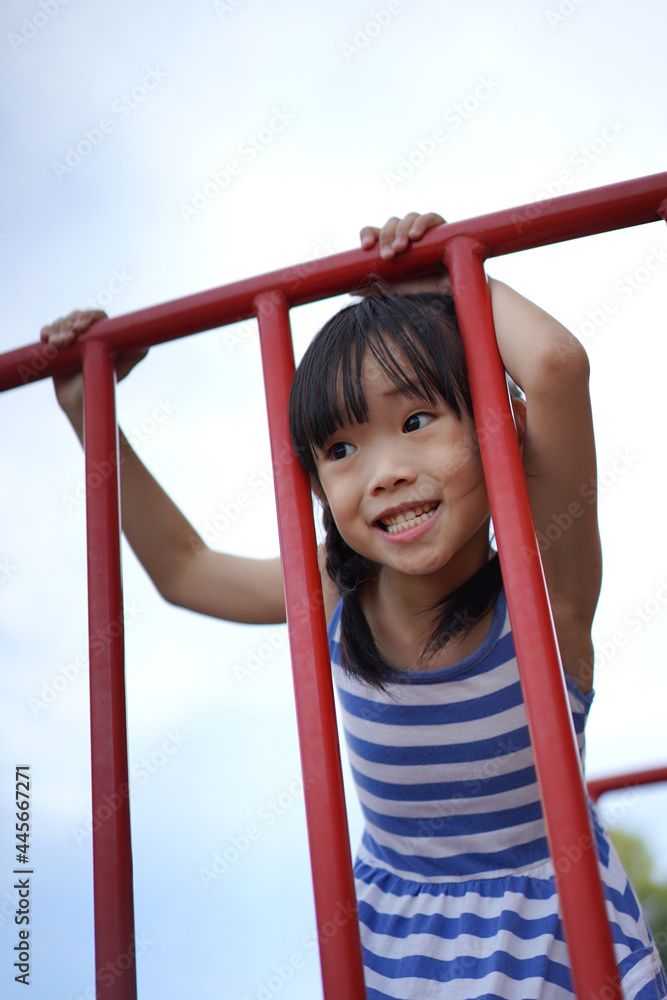 Fototapeta premium Happy little Asian girl having fun in the playground.