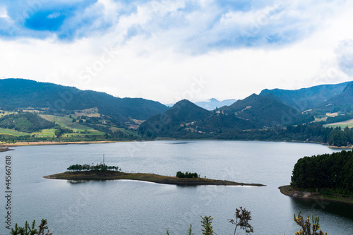 Neusa Reservoir in Colombia with a cloudy blue sky, mountains and forested areas. photo