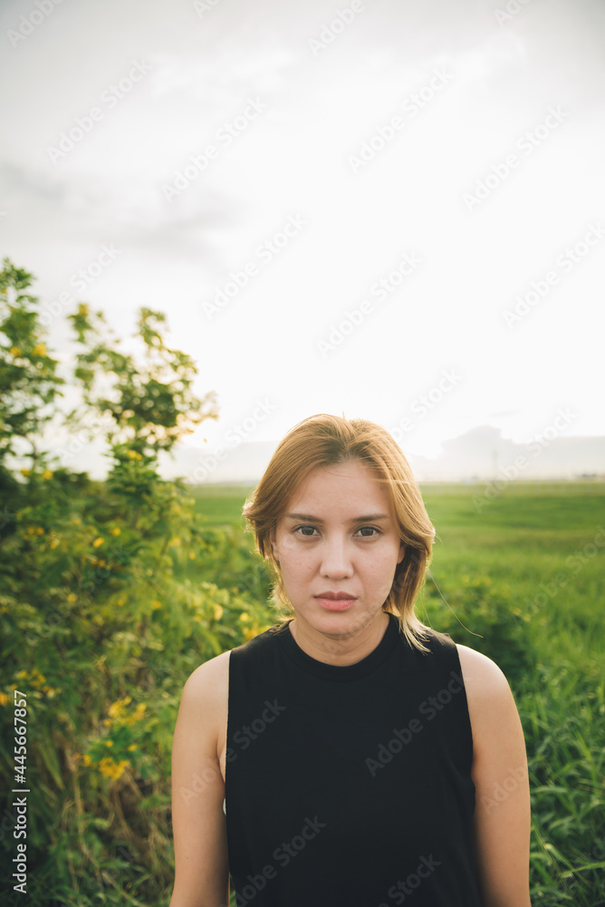 Young attractive asian woman in black dress on the field at sunset. Young attractive asian woman in black dress on the field at sunset.