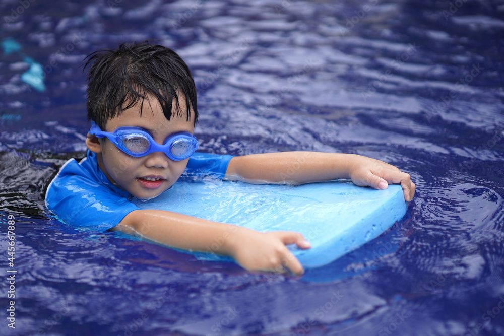 Little boy having fun while enjoying swimming in a pool. Summer concept.