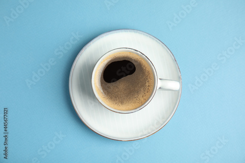Cup of hot aromatic espresso on light blue background, top view