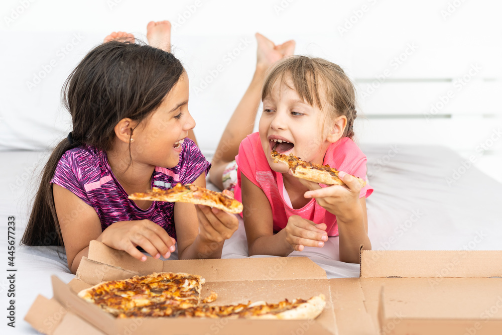 Two pretty young girls eating a slice of pizza Two pretty young girls eating a slice of pizza