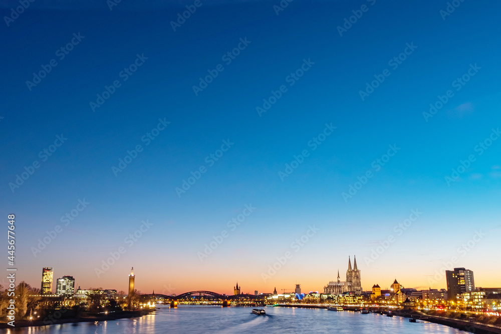 At night, the city center of Cologne, Germany, brightly lit on the Rhine, St. Martin's Church, Cologne Cathedral, distant view
