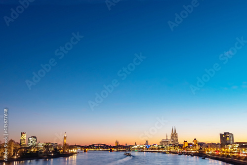 At night, the city center of Cologne, Germany, brightly lit on the Rhine, St. Martin's Church, Cologne Cathedral, distant view