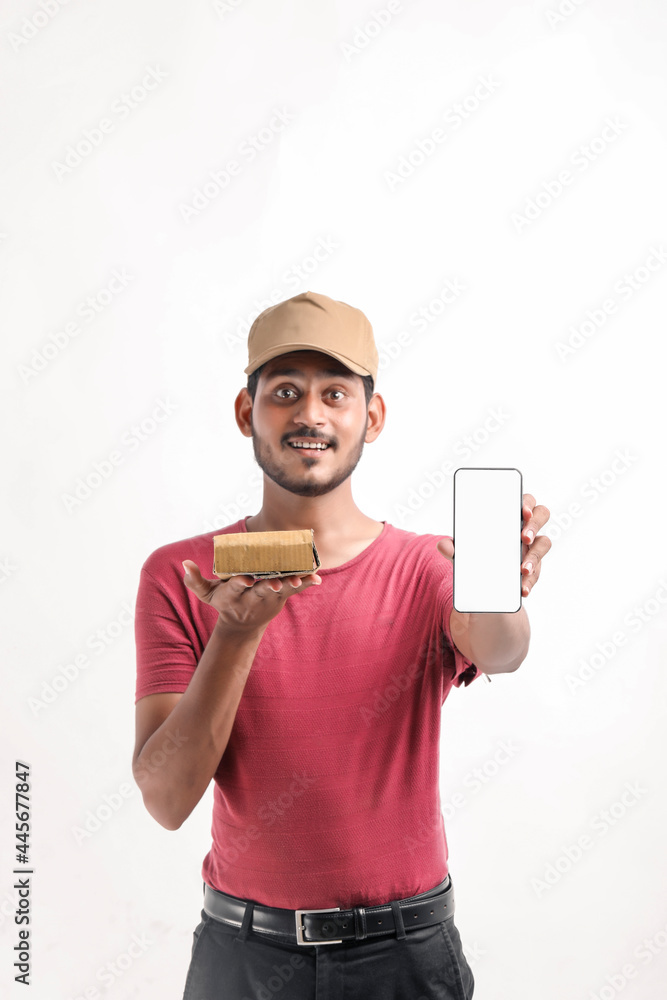 Portrait of a excited happy young delivery man in cap standing over white background. Looking camera showing display of mobile phone. Portrait of a excited happy young delivery man in cap standing over white background. Looking camera showing display of mobile phone.