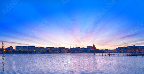 Early in the evening in Helsinki, Finland, the colorful sky and blue lake