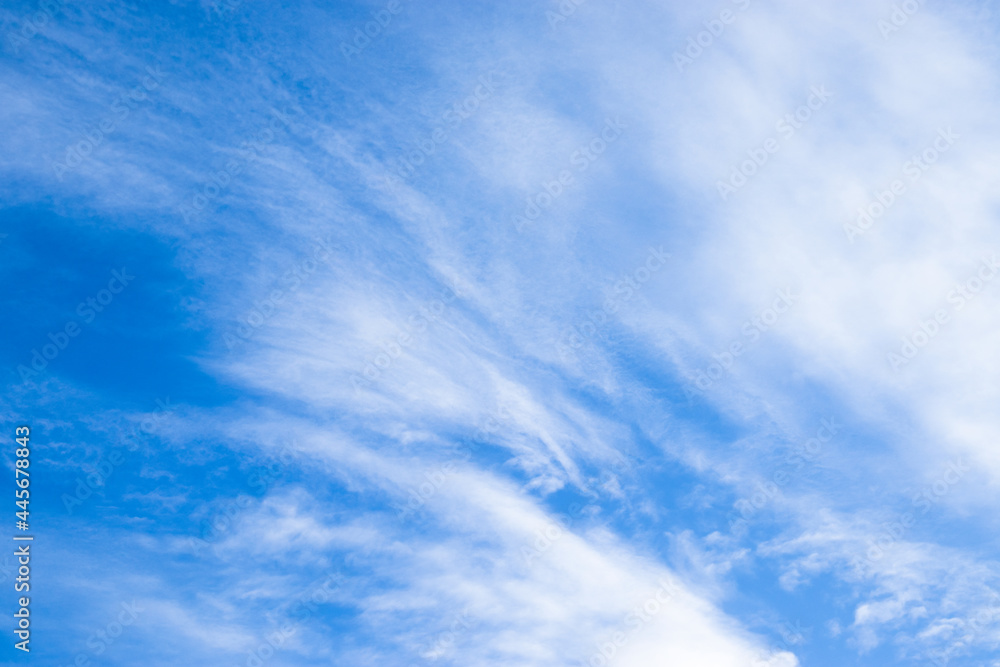 A landscape of blue skies and fluffy white clouds that spread across the daytime sky.