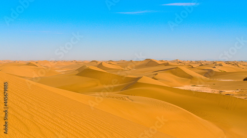 Close up of yellow desert under the blue sky with sand dunes formed by the wind