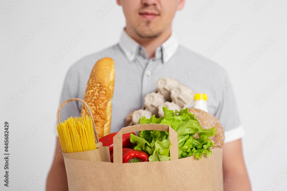 food delivery concept - close up of paper bag full of products in male hands over white food delivery concept - close up of paper bag full of products in male hands over white