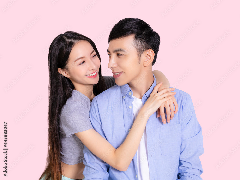 Young couple hugging and smiling isolated pink background.looking at each other. Young couple hugging and smiling isolated pink background.looking at each other.