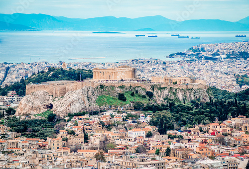 View of the Acropolis of Athens seen from Lycabettus Hill. The Filopappos Hill and the Saronic gulf  with the port and the city of Piraeus are in the background.