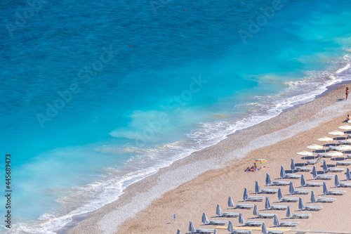 Colorful umbrellas and sunbeds on an empty beach resort - vacation concept on Greece islands in Aegean and Mediterranean seas. Akti Kanari Beach under Monte Smith in Rhodes city.