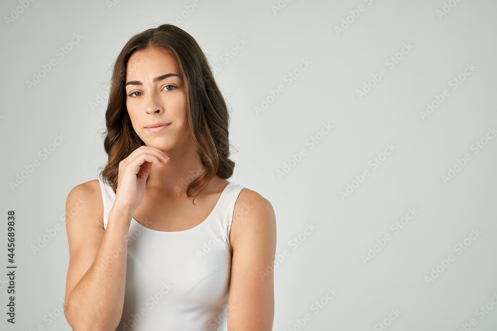 brunette with a serious expression in a white t-shirt dissatisfaction close-up brunette with a serious expression in a white t-shirt dissatisfaction close-up